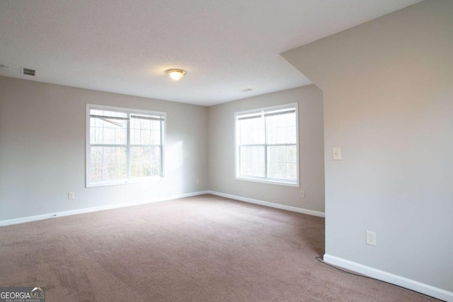 carpeted spare room featuring a textured ceiling