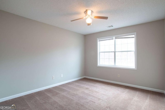 carpeted spare room with a textured ceiling and ceiling fan