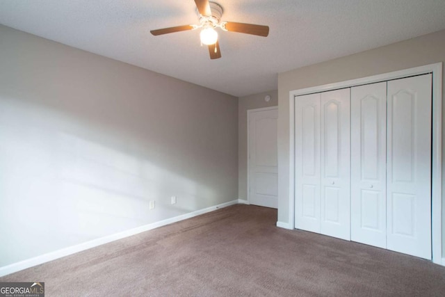 unfurnished bedroom featuring ceiling fan, a closet, carpet, and a textured ceiling