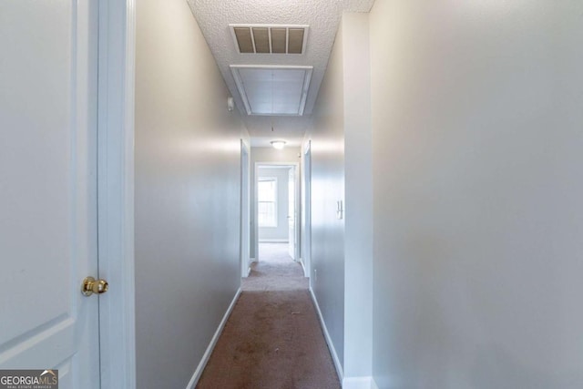 hall with carpet and a textured ceiling