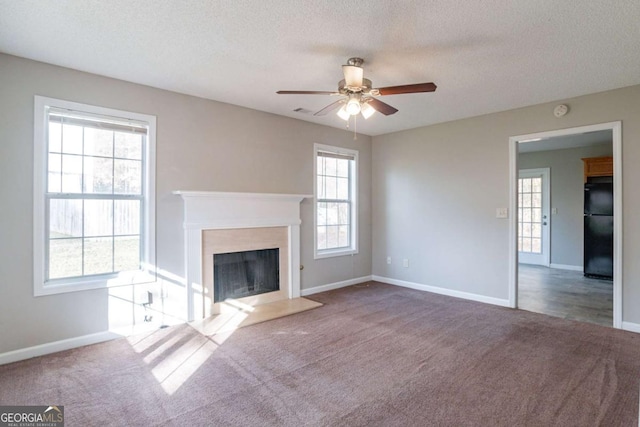 unfurnished living room with ceiling fan, carpet, and a textured ceiling