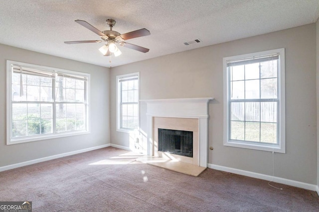 unfurnished living room with a textured ceiling, carpet floors, and ceiling fan