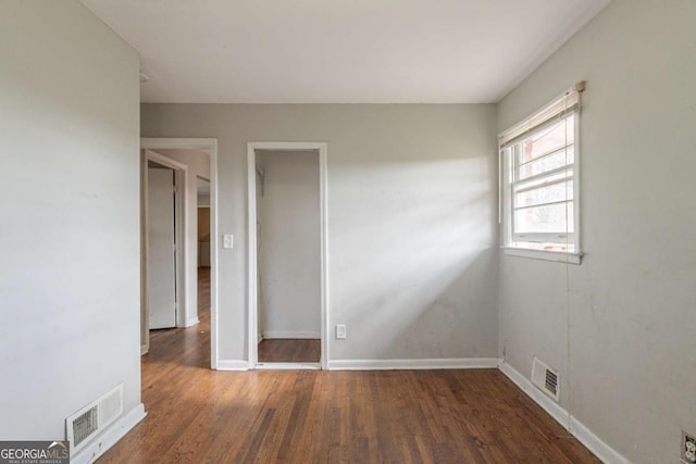 unfurnished room with dark wood-type flooring