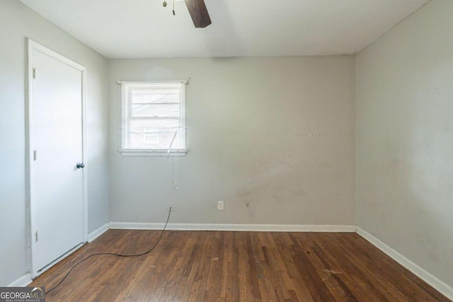 empty room with dark hardwood / wood-style floors and ceiling fan