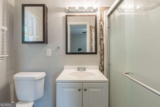 bathroom featuring an enclosed shower, vanity, and toilet