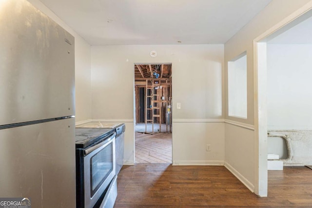 kitchen with dark hardwood / wood-style floors, range, and stainless steel refrigerator