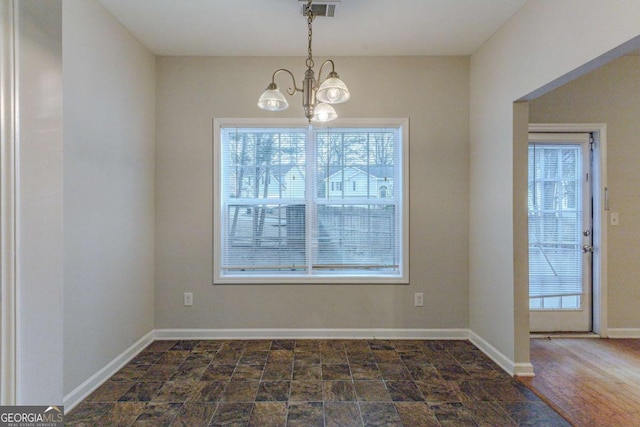 unfurnished dining area with dark wood-type flooring and a chandelier