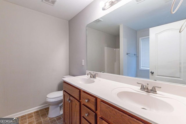 bathroom featuring walk in shower, vanity, and toilet