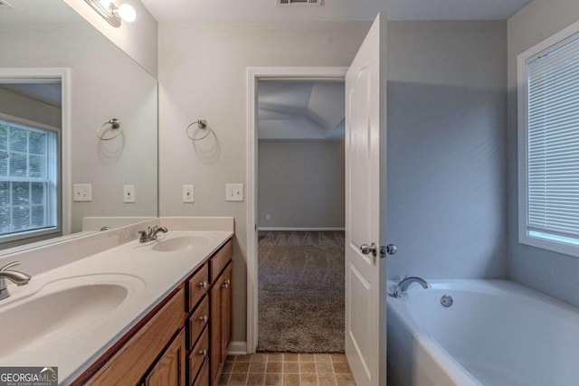 bathroom with a washtub and vanity