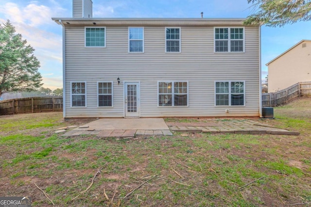 back of house with central AC unit, a patio area, and a yard