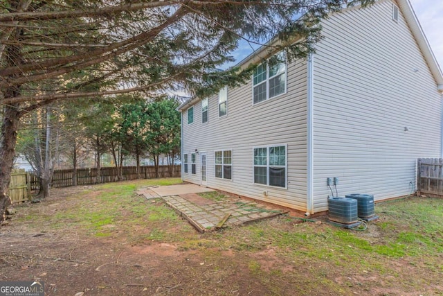 back of property with central AC and a patio