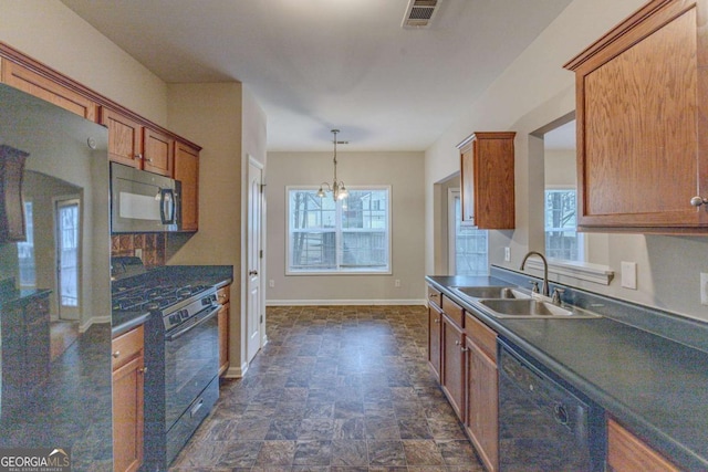 kitchen featuring pendant lighting, a wealth of natural light, sink, and black appliances