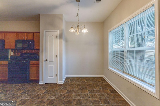 kitchen with a wealth of natural light, black appliances, decorative light fixtures, and a notable chandelier