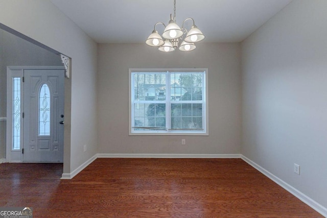 entryway with dark hardwood / wood-style floors and an inviting chandelier