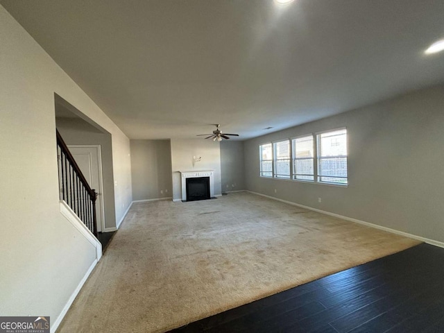 unfurnished living room featuring carpet flooring and ceiling fan