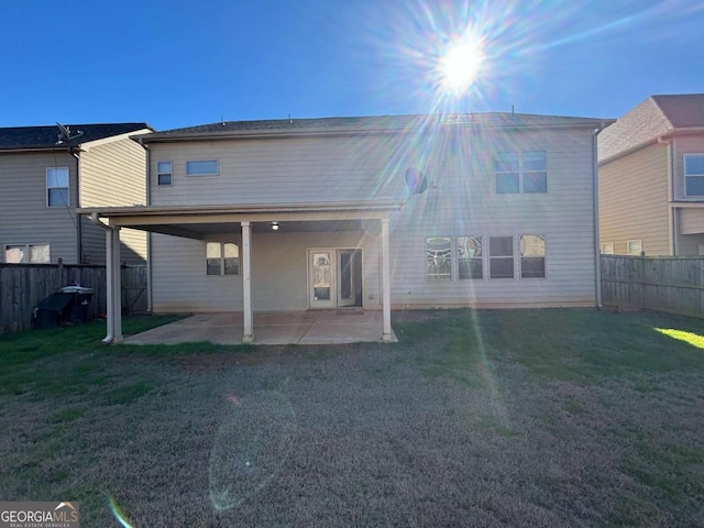 back of property with a lawn and a patio area