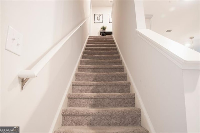 stairway featuring carpet