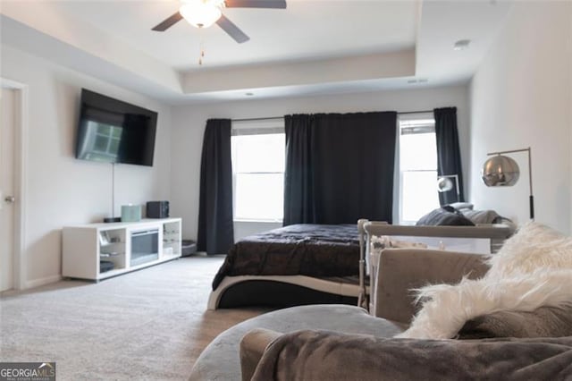 bedroom featuring a tray ceiling, ceiling fan, and light colored carpet