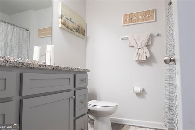 bathroom featuring hardwood / wood-style flooring, vanity, and toilet