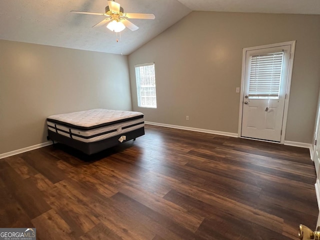 unfurnished bedroom with dark hardwood / wood-style floors, vaulted ceiling, and ceiling fan