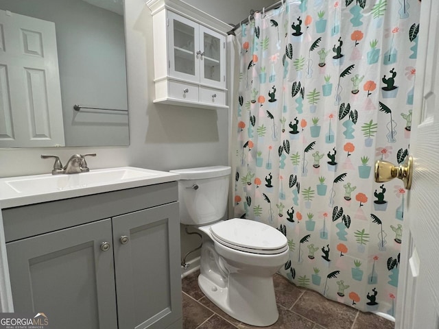 bathroom featuring curtained shower, tile patterned flooring, vanity, and toilet