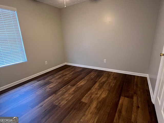 spare room with dark wood-type flooring