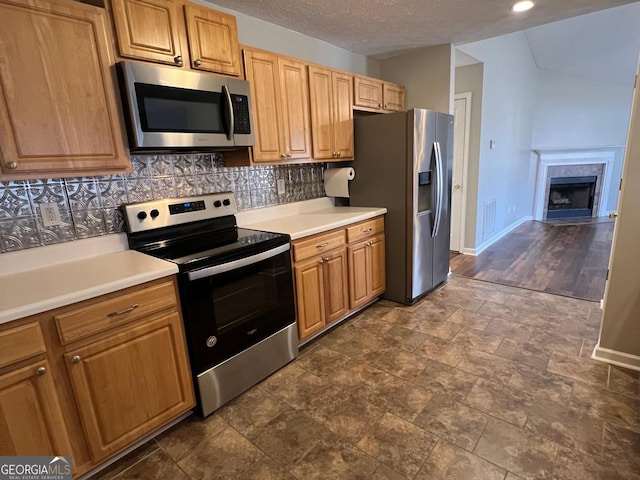 kitchen with decorative backsplash, appliances with stainless steel finishes, a textured ceiling, and dark hardwood / wood-style floors