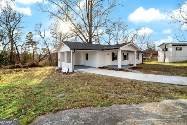 view of front of property featuring a front yard and a carport