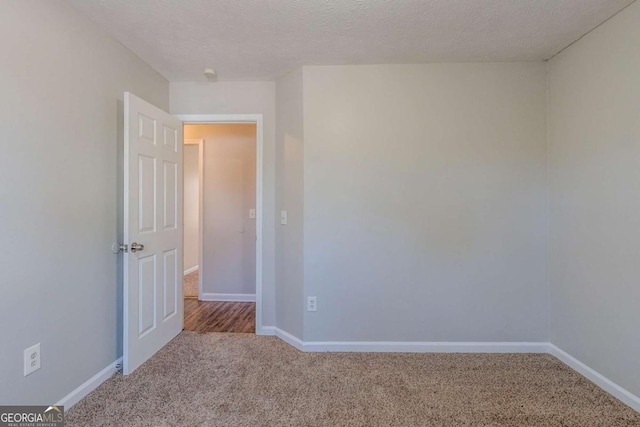 carpeted empty room with a textured ceiling