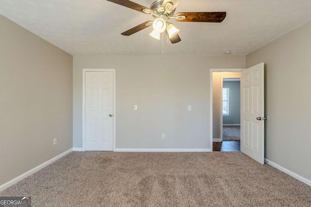 spare room featuring ceiling fan, carpet, and a textured ceiling