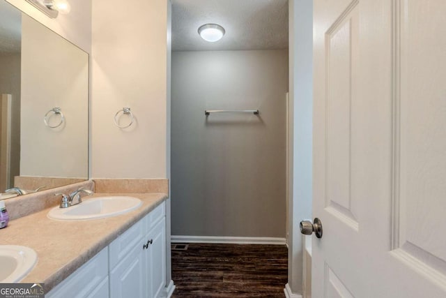 bathroom featuring vanity, wood-type flooring, and a textured ceiling