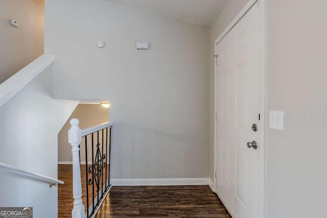 staircase with wood-type flooring and a textured ceiling