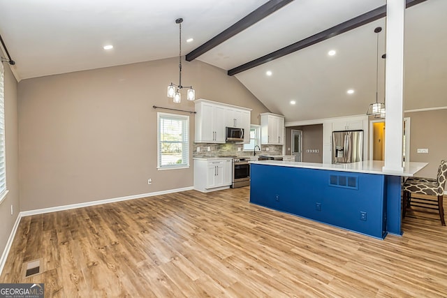 3625 Pointer Rd, Loganville, GA 30052 - kitchen with stainless steel appliances, light countertops, white cabinets, light wood finished floors, and decorative backsplash