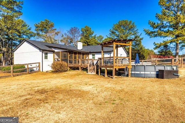 3625 Pointer Rd, Loganville, GA 30052 - back of house with a sunroom, a deck, a chimney, an outdoor pool, and a shingled roof