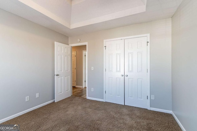 unfurnished bedroom with a textured ceiling, carpet floors, and a closet