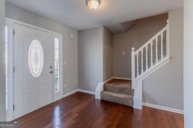 entryway featuring a textured ceiling and dark wood-type flooring