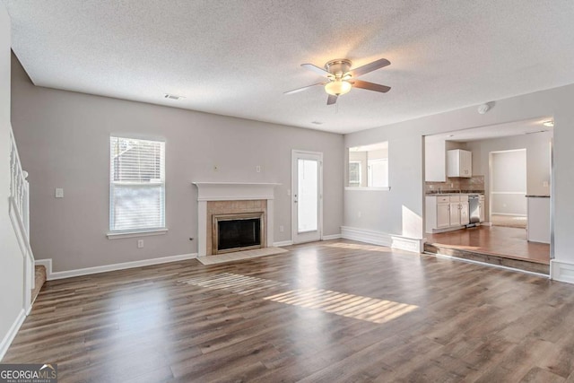 unfurnished living room with dark hardwood / wood-style flooring, a textured ceiling, and a wealth of natural light