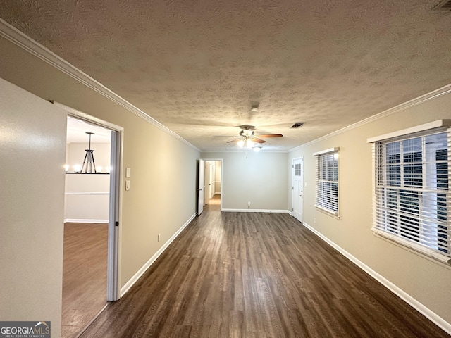 empty room with a textured ceiling, dark hardwood / wood-style floors, ornamental molding, and ceiling fan with notable chandelier