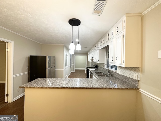 kitchen with kitchen peninsula, appliances with stainless steel finishes, light stone countertops, white cabinets, and dark hardwood / wood-style floors