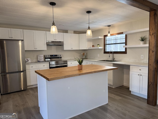 kitchen with under cabinet range hood, stainless steel appliances, white cabinets, a center island, and open shelves