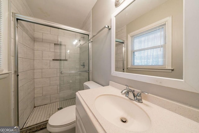 bathroom with vanity, toilet, and a shower with door