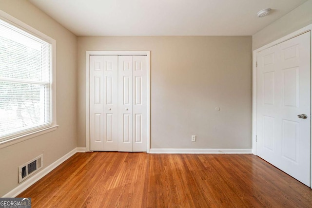 unfurnished bedroom featuring hardwood / wood-style flooring and a closet