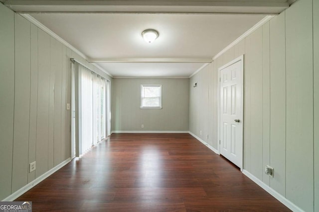 unfurnished room with dark hardwood / wood-style floors, ornamental molding, and wood walls