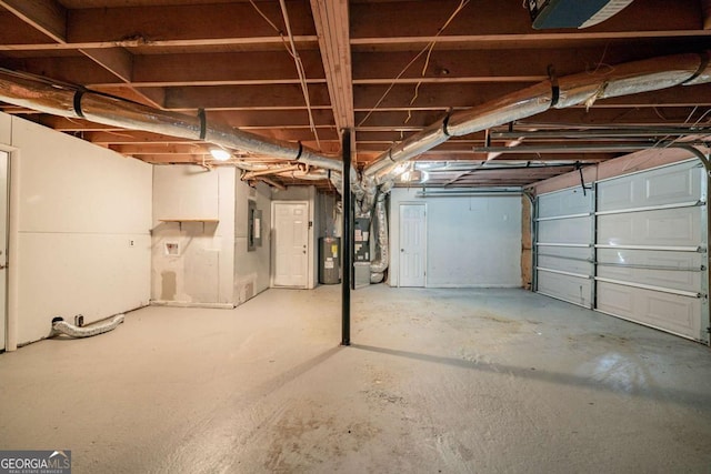 garage featuring electric water heater and heating unit