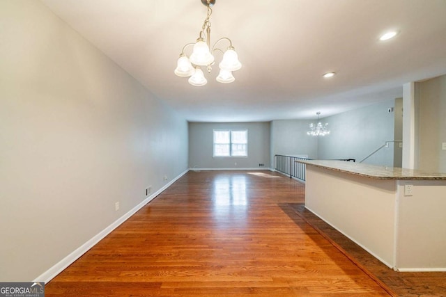 interior space featuring hardwood / wood-style flooring and an inviting chandelier