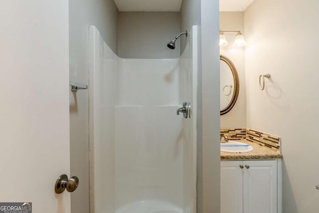 bathroom featuring a shower and vanity