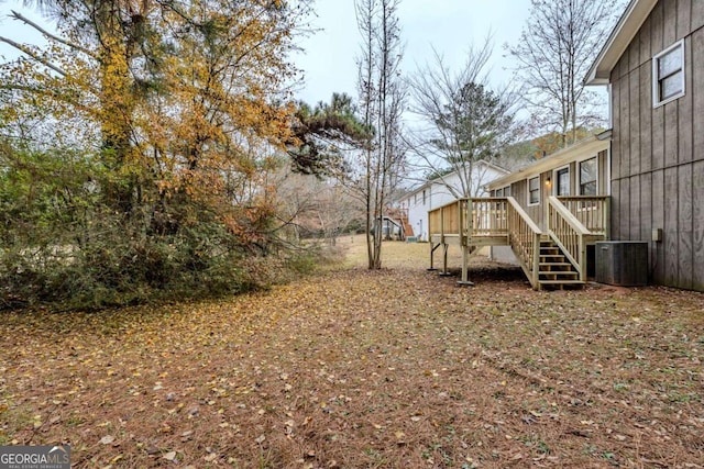 view of yard with a deck and central AC unit