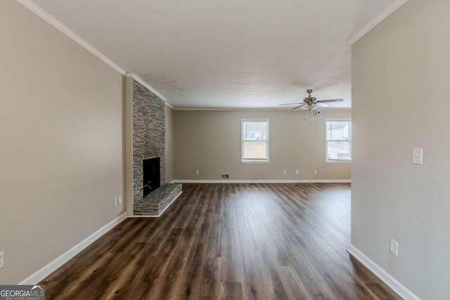 unfurnished living room with a fireplace, ceiling fan, crown molding, and dark wood-type flooring