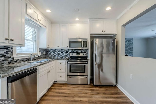 kitchen with white cabinets, crown molding, sink, dark hardwood / wood-style floors, and stainless steel appliances