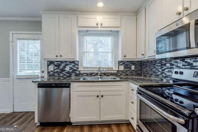 kitchen featuring appliances with stainless steel finishes, white cabinetry, a healthy amount of sunlight, and sink